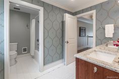 a bathroom with marble counter tops and white walls