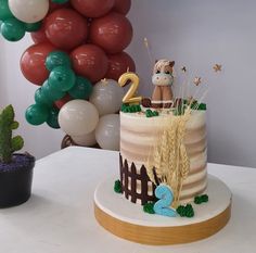 a birthday cake decorated with farm animals and balloons