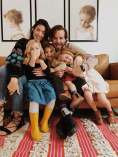 a man and two women sitting on a couch with their children