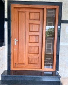 a close up of a wooden door on a stone building with black steps and windows