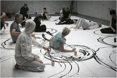 a group of people sitting on the ground working on something