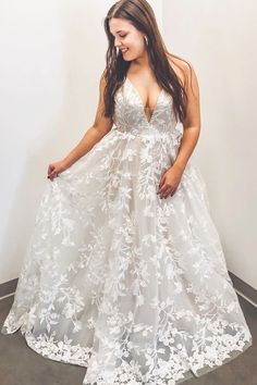 a woman in a white dress standing next to a wall