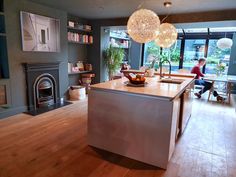 a person sitting at a table in a kitchen next to a fire place and fireplace