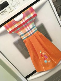 an orange dress is hanging on the oven door