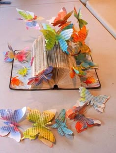 an open book sitting on top of a table covered in butterflies