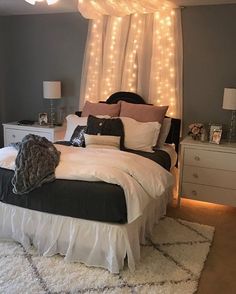 a bedroom with lights on the ceiling and a white bed