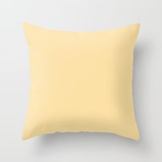 a yellow pillow on a white wall