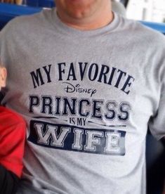 a man holding a baby in his lap while wearing a shirt that says, my favorite princess is my wife