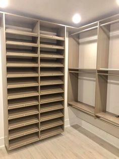 an empty walk in closet with lots of shelves