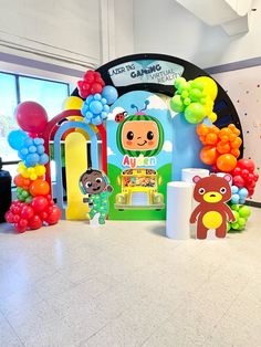 there are balloons and decorations on the floor in front of a wall with cartoon characters