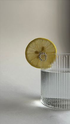 a glass with water and a lemon slice in it