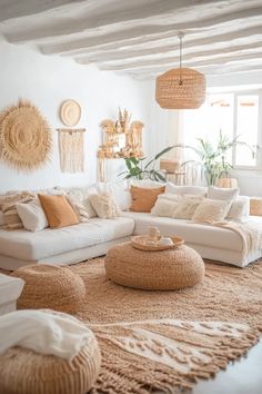 a living room filled with lots of white furniture and pillows on top of a rug