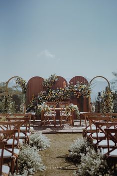 an outdoor ceremony setup with flowers and chairs