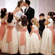 a bride and groom kissing in front of their children