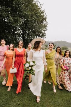 a group of women standing next to each other on top of a lush green field