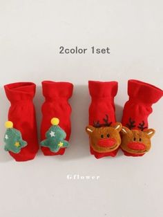 three red socks with christmas decorations on them, one is for the baby and two are for the toddler