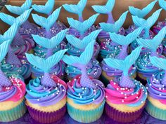 cupcakes decorated with blue and purple icing, mermaid tail decorations and pearls