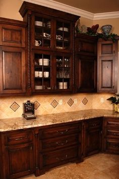 a kitchen with wooden cabinets and marble counter tops