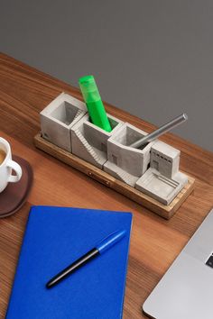 a laptop computer sitting on top of a wooden desk next to a cup of coffee