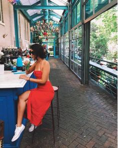 a woman in a red dress sitting at a counter