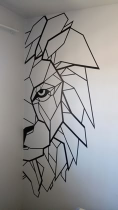 a black and white drawing of a lion's head on the wall next to a bed