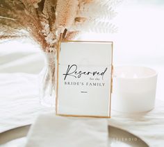 a table with a white candle and a sign on it that says reserved for the bride's family