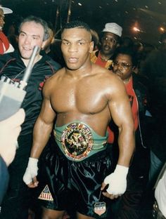 a man in a boxing ring surrounded by people