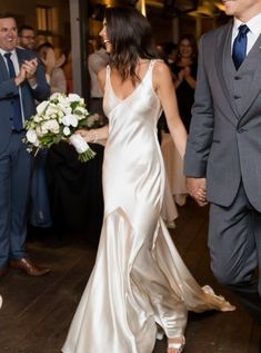 a bride and groom walking down the dance floor