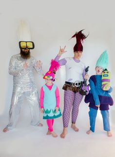 four people dressed up in costumes and wigs posing for the camera with one person holding his hand out