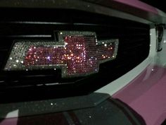 the front end of a pink car with sequins on it