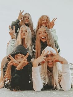 four girls posing for the camera with their hands in the air