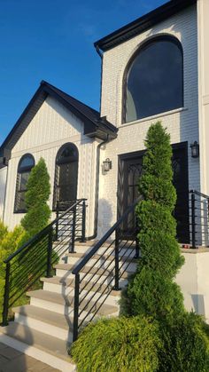 a white house with black trim and stairs