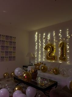 a living room filled with lots of balloons and gold numbers on the wall above it