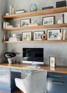 a desk with a computer on top of it next to some books and other items