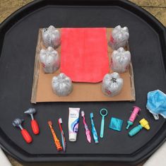 a black tray topped with lots of different types of toys and items on top of it