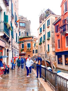 people are walking down the street on a rainy day