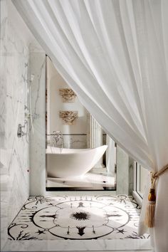 a white bath tub sitting under a bathroom window