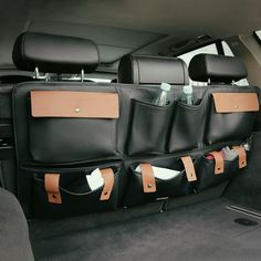 the back seat of a car with two leather bags on it's side pockets