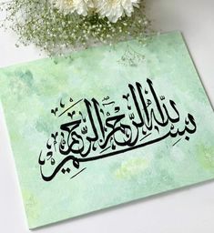 an arabic calligraphy is displayed on a green background with white flowers in the foreground