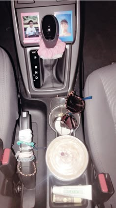 the interior of a car with various items in it and pictures on the dash board