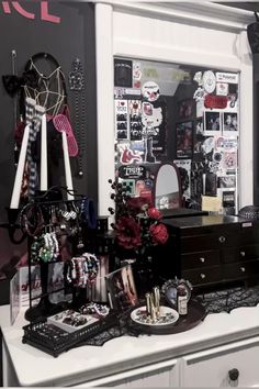 an assortment of jewelry on display in a room with black and white wallpapers