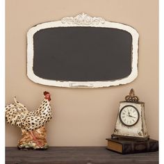 a chicken statue sitting on top of a wooden table next to a chalkboard and clock