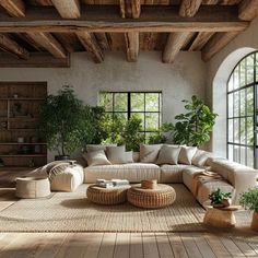 a living room filled with lots of furniture and plants on top of wooden flooring