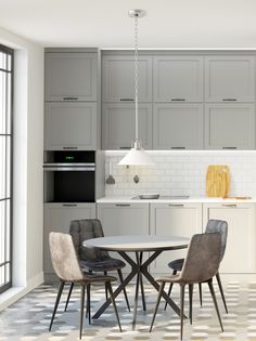 a kitchen with gray cabinets and white counter tops, an oven, microwave and dining table in the center