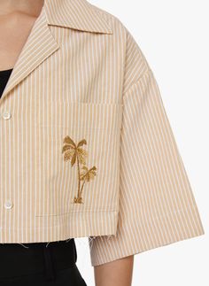 Aspect rayé  Coupe courte  Col cubain   Fermeture boutonnée  Manches courtes  Broderie avant - Comme le laisse deviner le petit palmier brodé sur le côté gauche de la poitrine, cette chemise est l'oeuvre du label Palm Angels. Confectionné en coton, ce modèle séduit par sa coupe raccourcie, son col cubain et sa fermeture boutonnée. Une création à l'aura cool et décontractée.       Aspect :  - Coupe :  - Fermeture :  - Manches :  - Col :  - Palm Angels