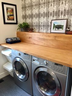 a washer and dryer in a room with a wooden shelf above the washer