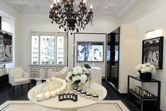 a living room filled with white furniture and chandelier