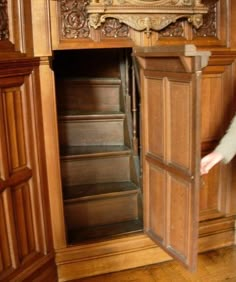 a woman standing next to a tall wooden cabinet in a room with wood paneling