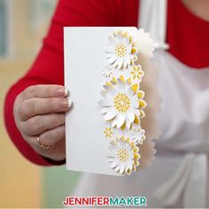 a woman holding up a card with flowers on it