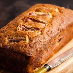 a loaf of bread sitting on top of a wooden cutting board next to a knife